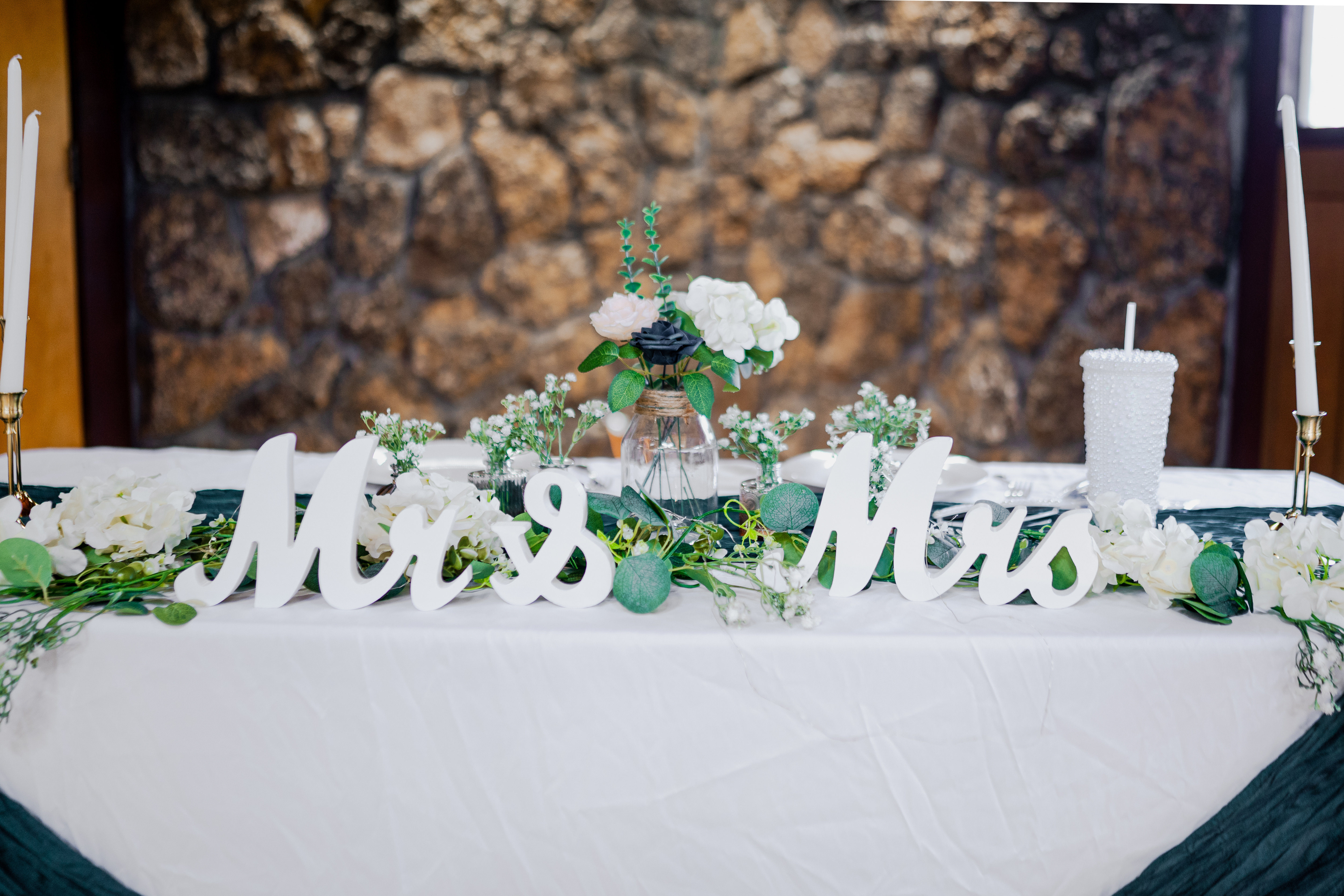The wedding table and floral details, with the couple’s Mr & Mrs sign