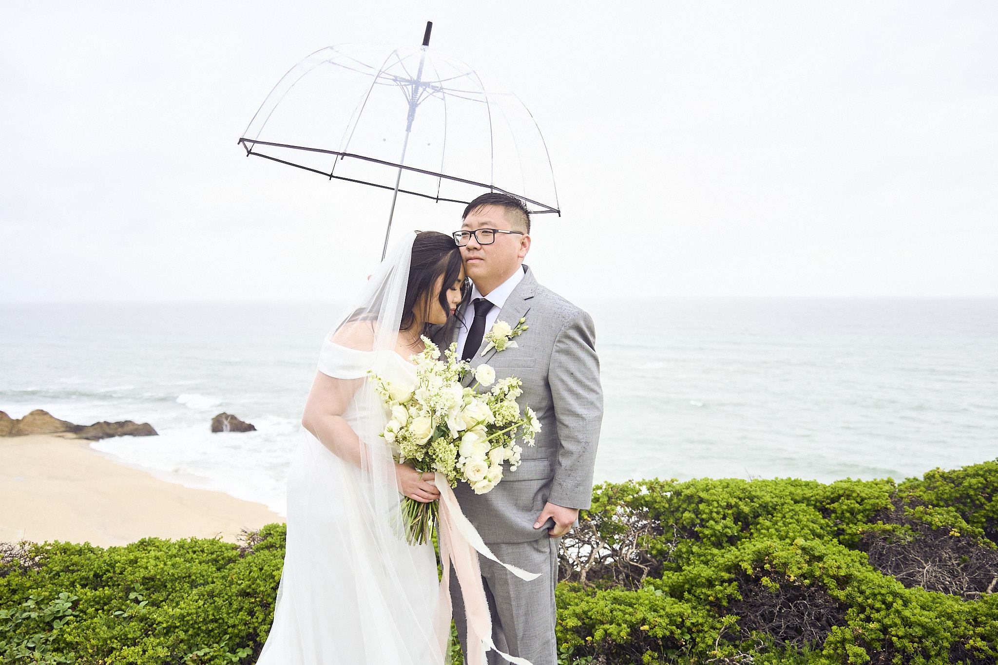 A close portrait together beneath a clear umbrella